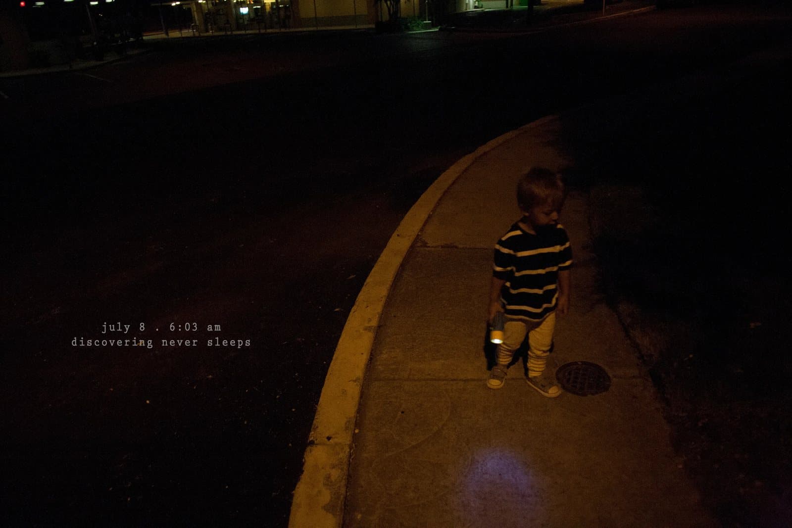 A toddler walks along a dark street curb at dawn, captioned discovering never sleeps.