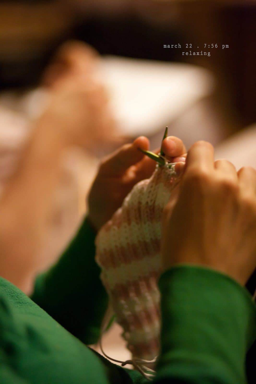 Close-up of hands knitting a pink and cream piece, captioned relaxing.