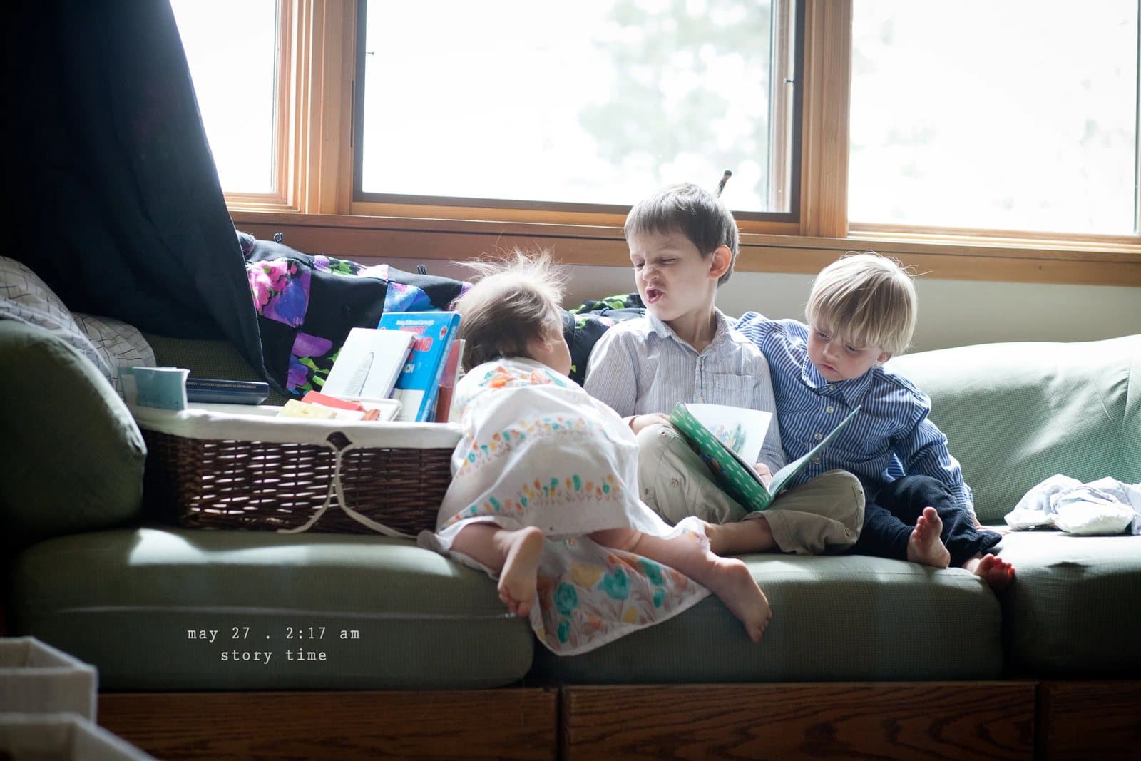Three children read books together on a green couch, captioned story time.