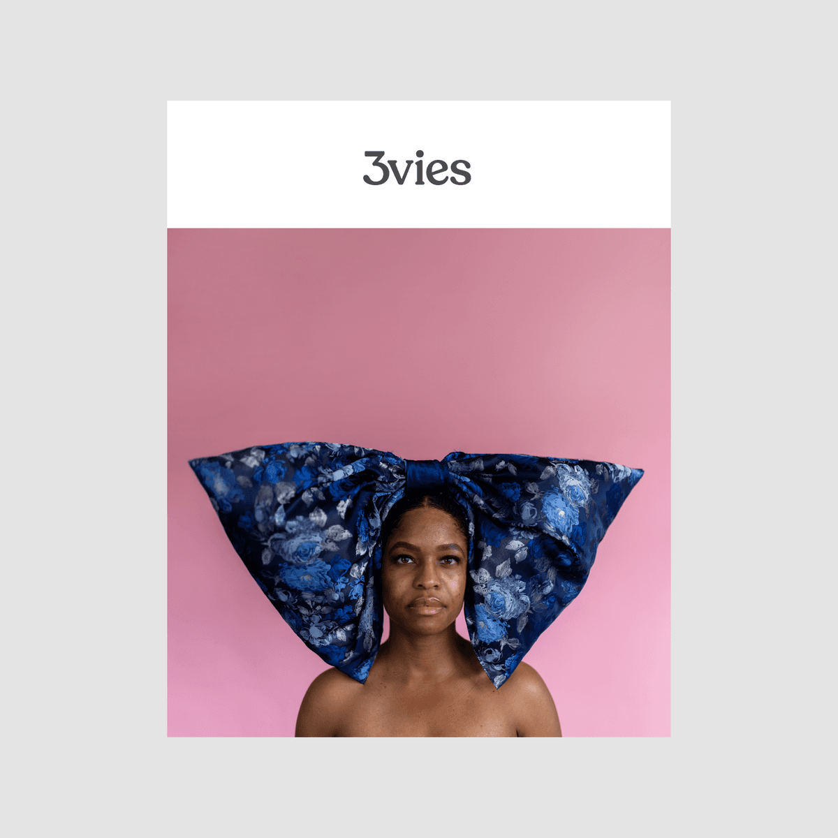 Cover of 3vies Volume 39, a woman wearing an oversized blue floral bow against a pink backdrop.