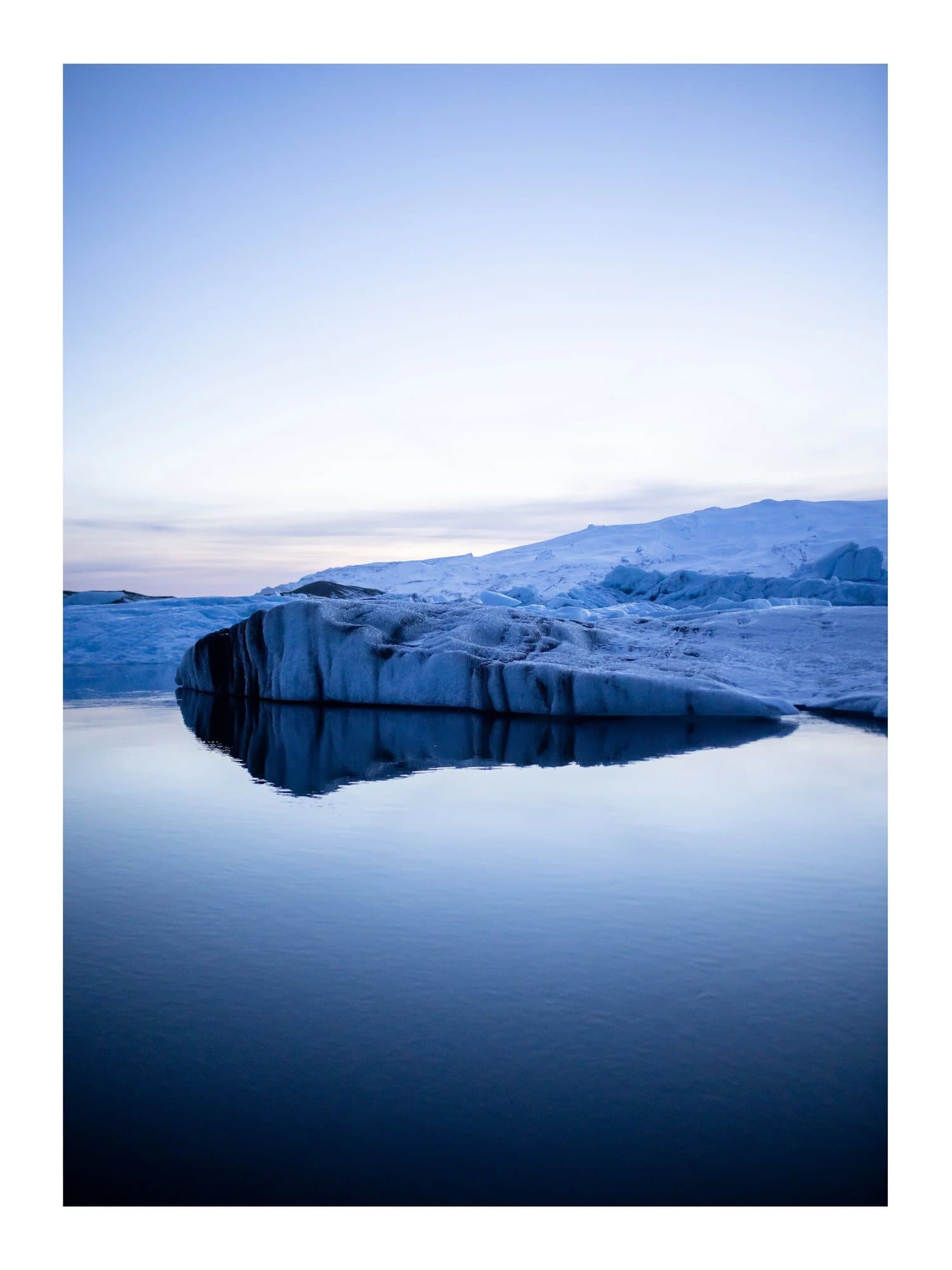 A glacier reflected in still water at dusk, TIMELESS print Iceland Blue Hour.