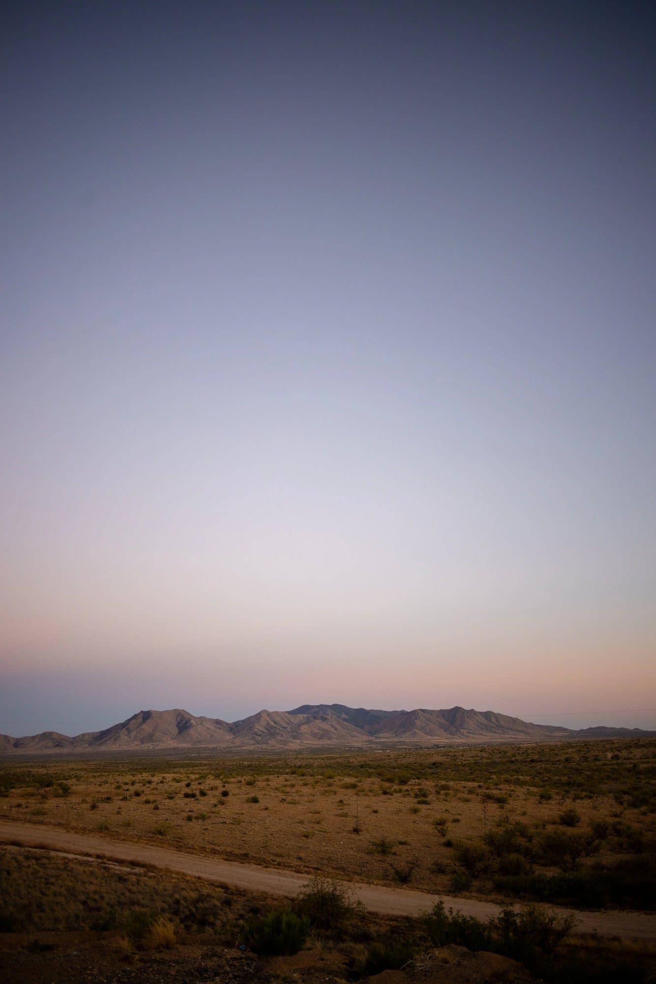 Photo handout of a desert road and distant mountains under a pastel dusk sky in Arizona.