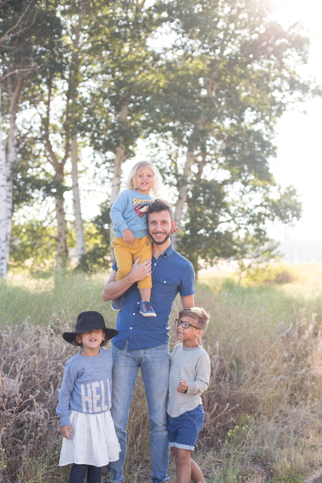 Photo handout of Mark with his three young children in a sunny field, one child on his shoulders.