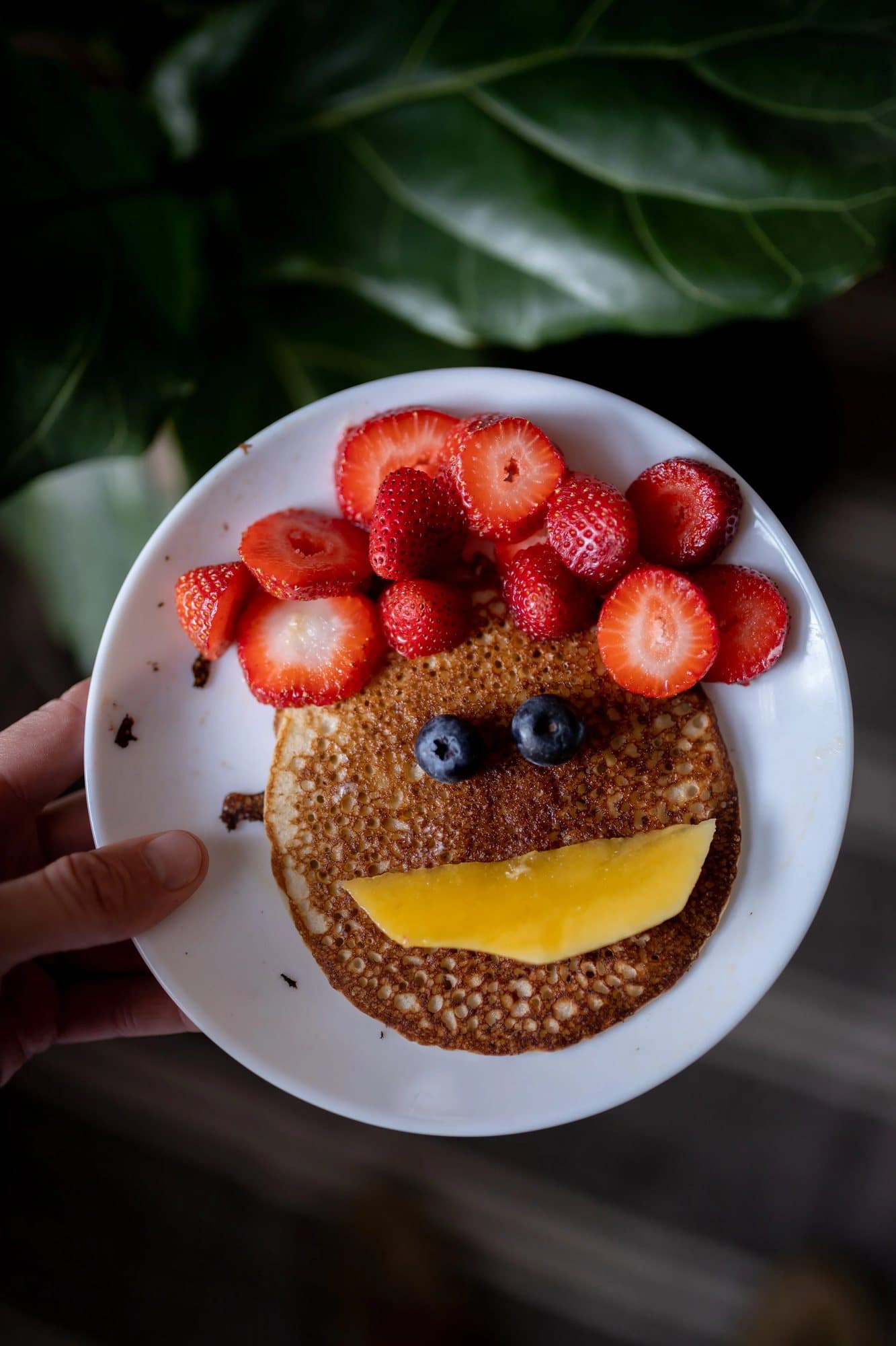 Photo handout of a pancake face with strawberry hair, blueberry eyes and a mango smile.
