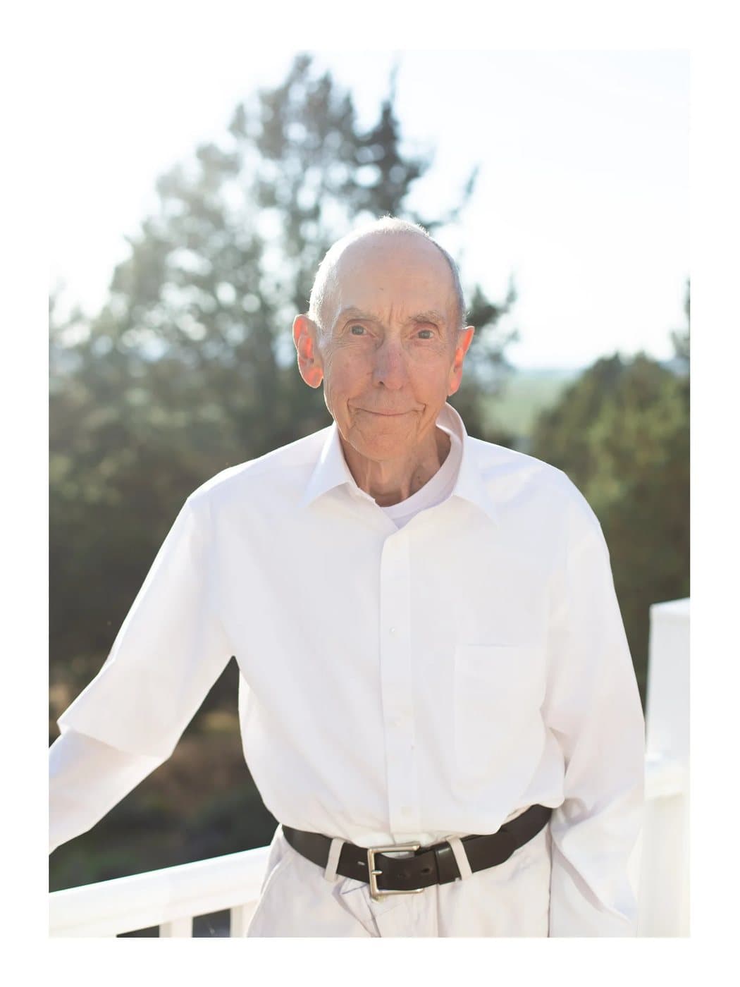 Grandpa, a TIMELESS archival print of an elderly man in a white shirt on a sunlit porch.