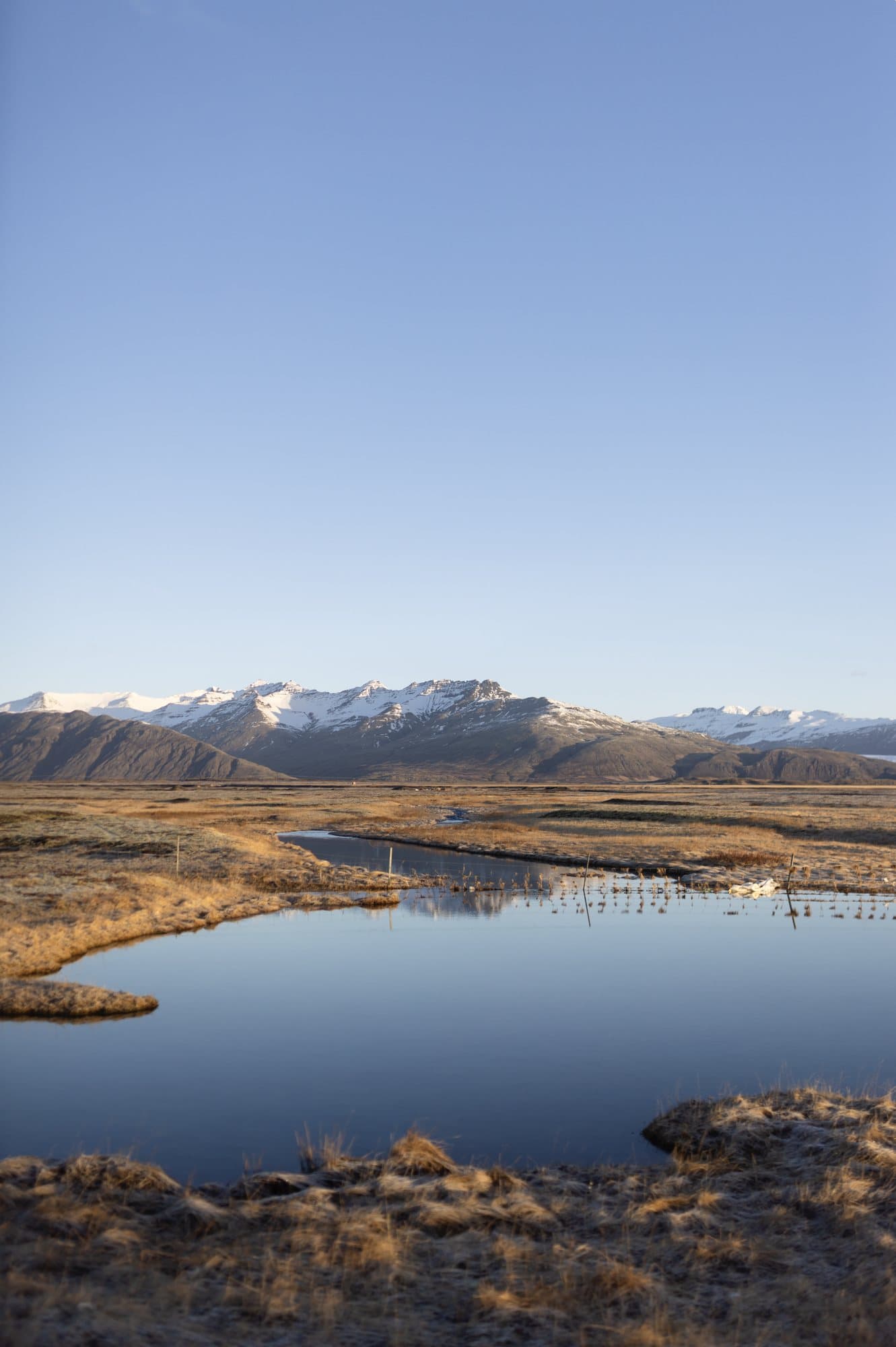 Photo handout of a still pond reflecting snowcapped mountains under a clear Icelandic sky.