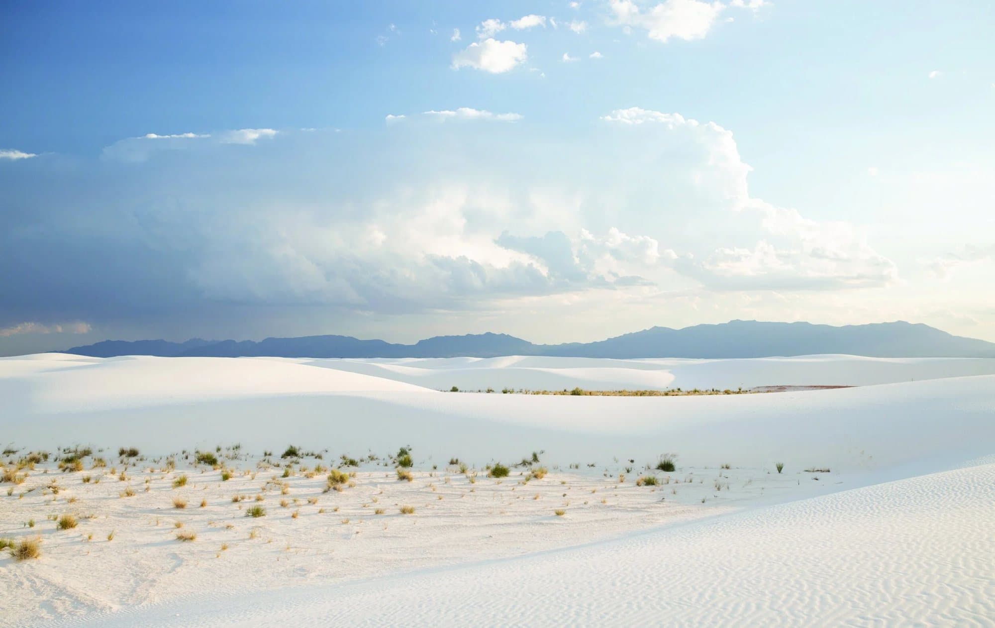 Spread from Volume 35 showing a wide panorama of White Sands dunes under towering clouds.