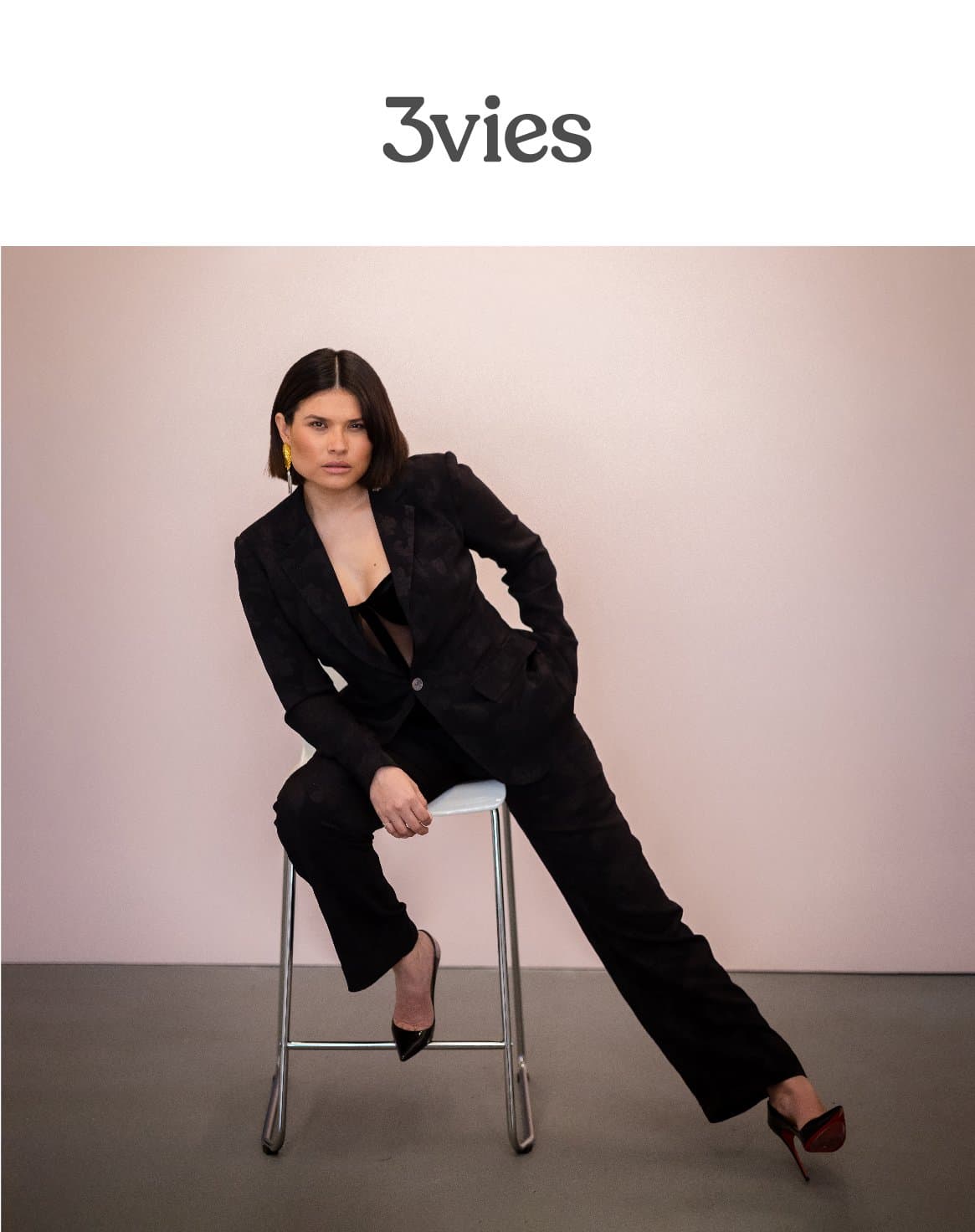 Cover of 3vies Volume 37, Into The Open, a woman in a black suit seated against a pink wall.