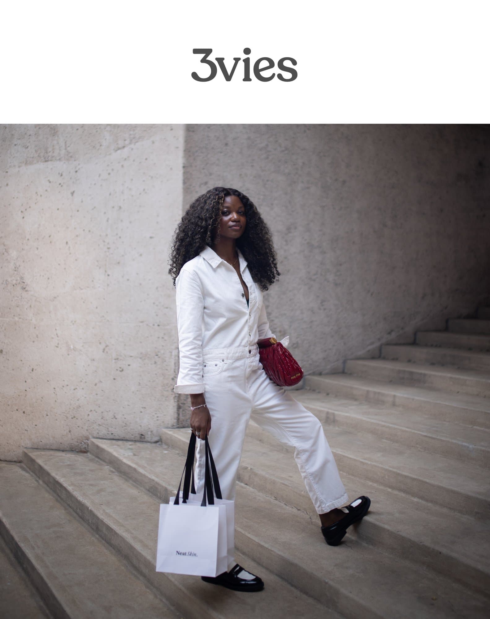 Cover of 3vies Volume 38, Looking, a woman in a white jumpsuit with a red bag on concrete steps.