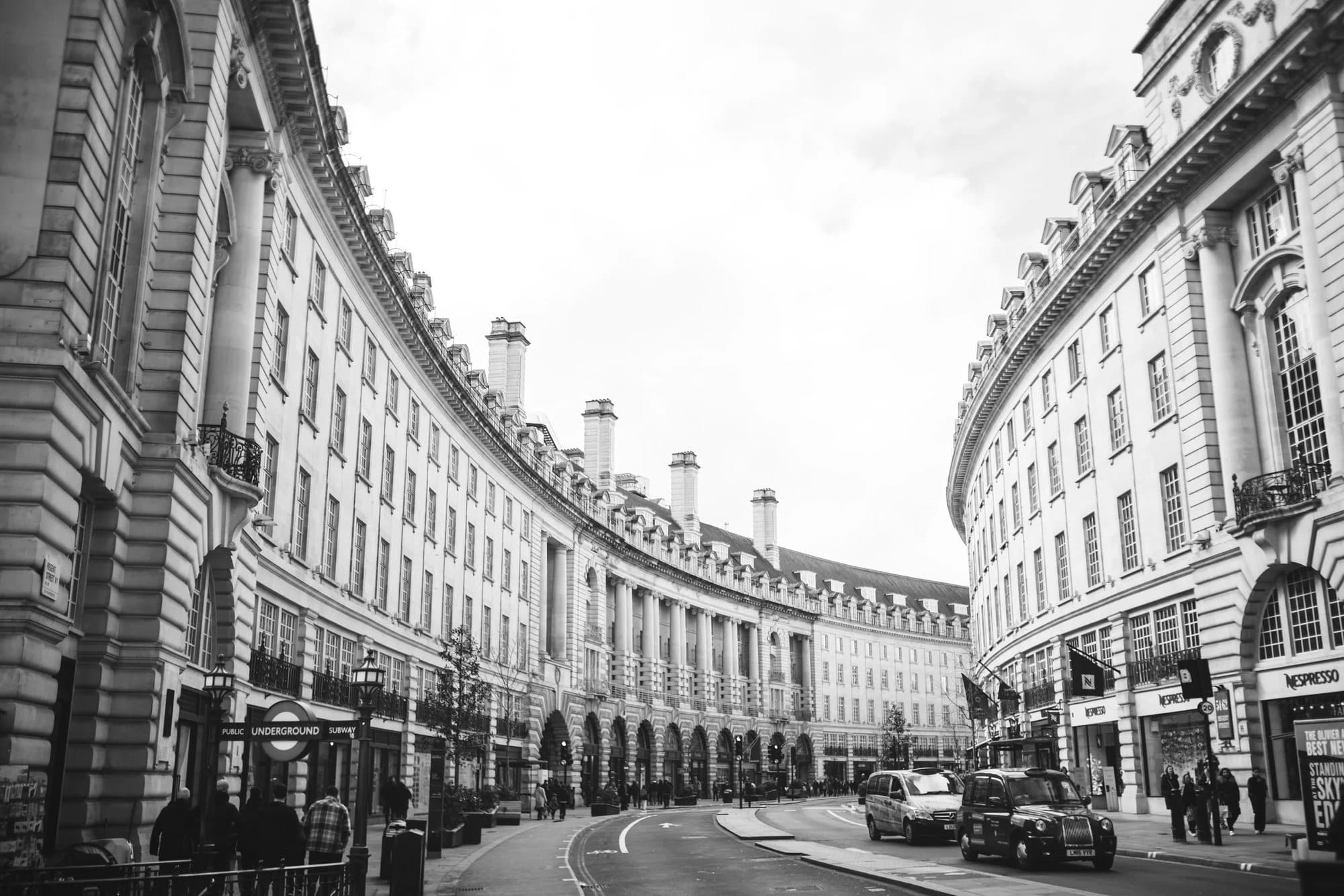 Black and white view of the curving facades of Regent Street in London.
