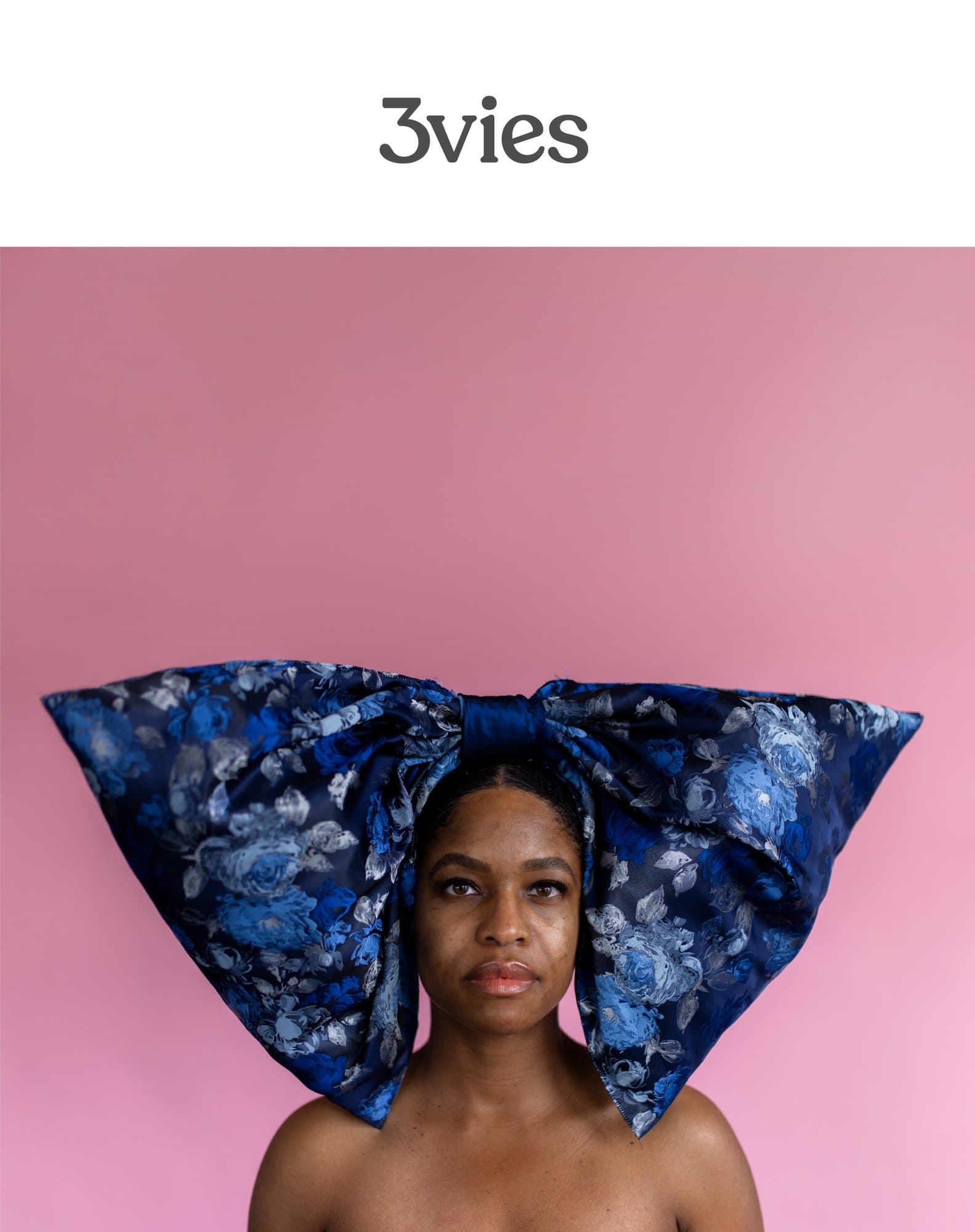 Cover of 3vies Volume 39, Forward, a woman wearing an oversized blue floral bow against a pink backdrop.