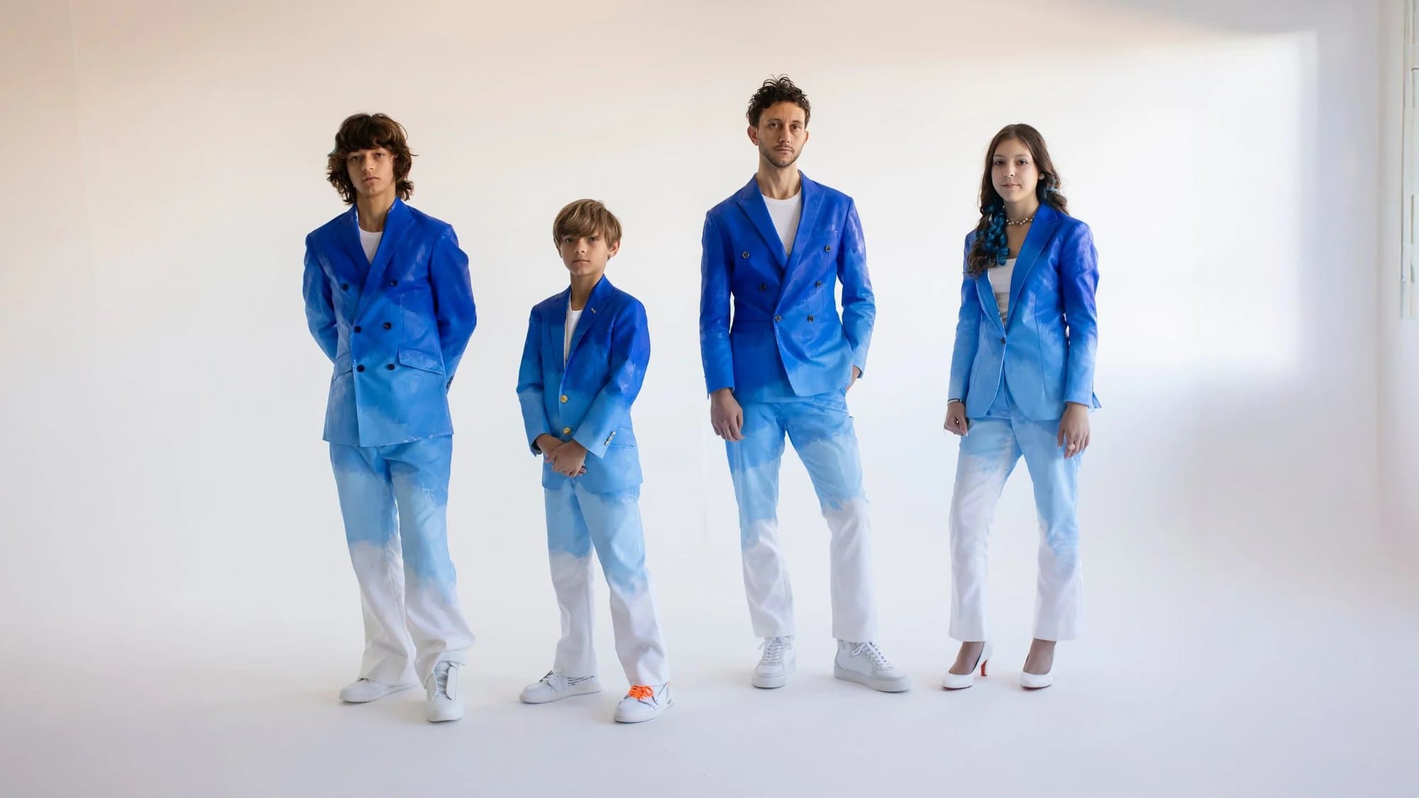 Mark and his three children in matching hand-painted blue ombre suits, the wearable centerpiece of the Timeless exhibit.
