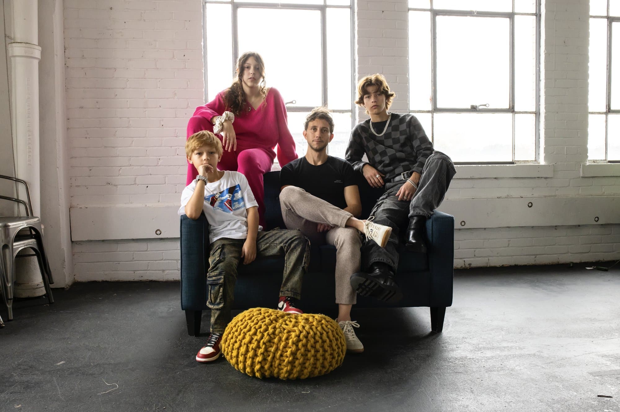 Mark sits on a sofa with his three children in a sunlit loft, the kids whose visions of the future inspired this.