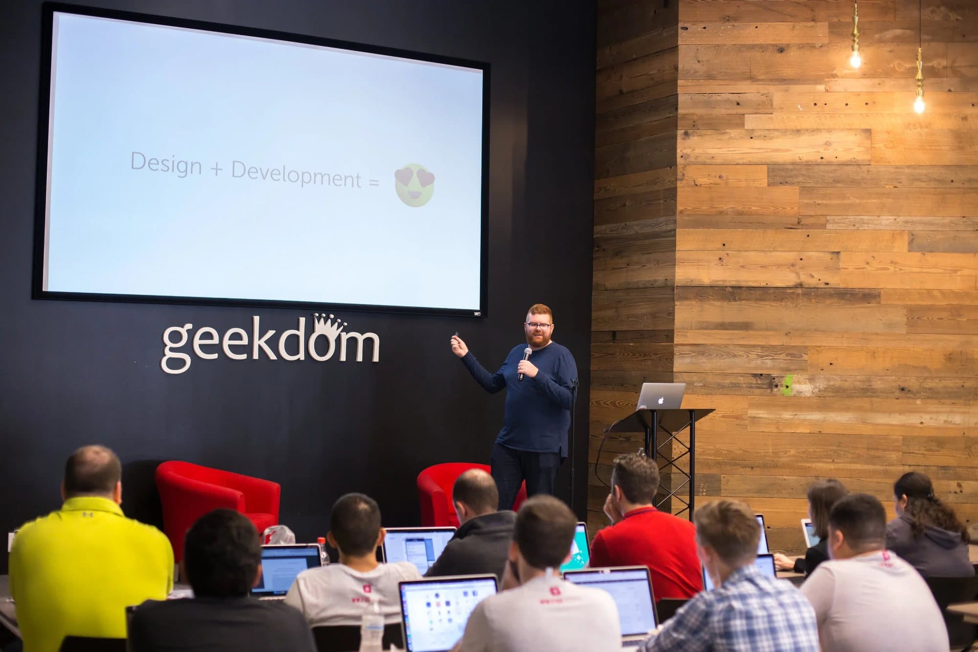 A speaker presents a Design + Development slide to laptop-toting attendees at Geekdom during WW@SA 2017.