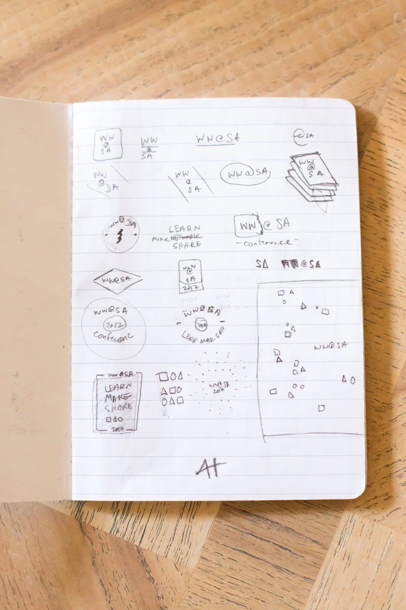 A sketchbook page of WW@SA logo and banner ideas, including Learn Make Share badges and scattered shapes.